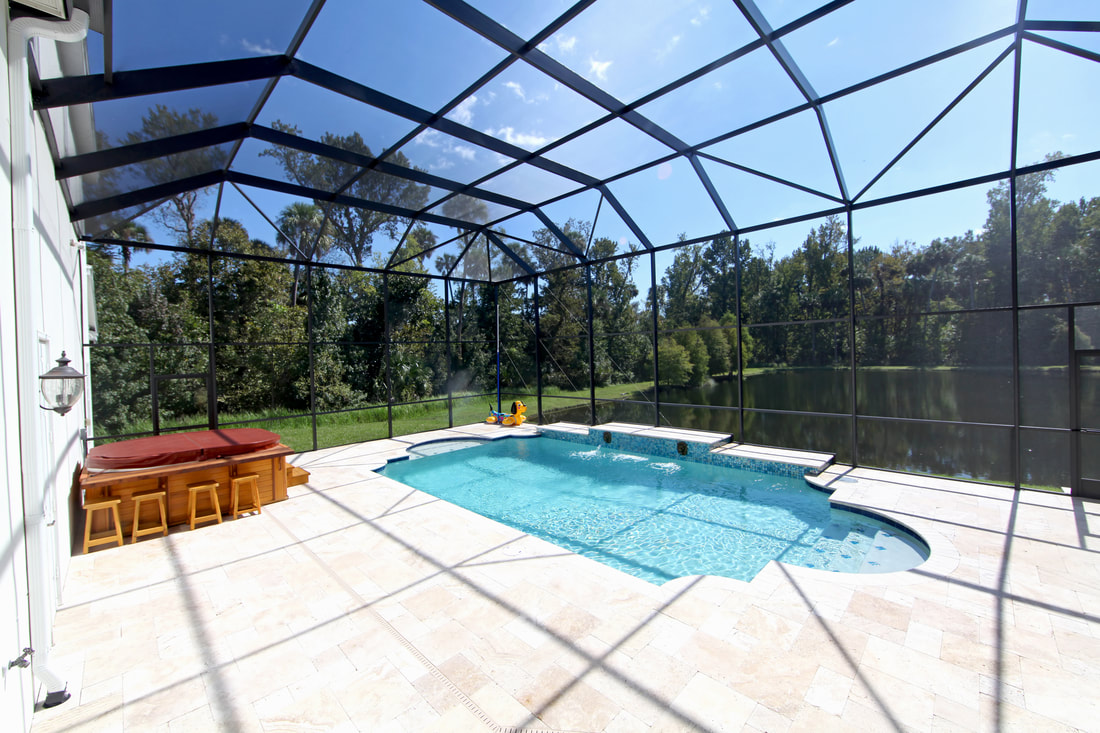a pool enclosure with a jacuzzi and lake view